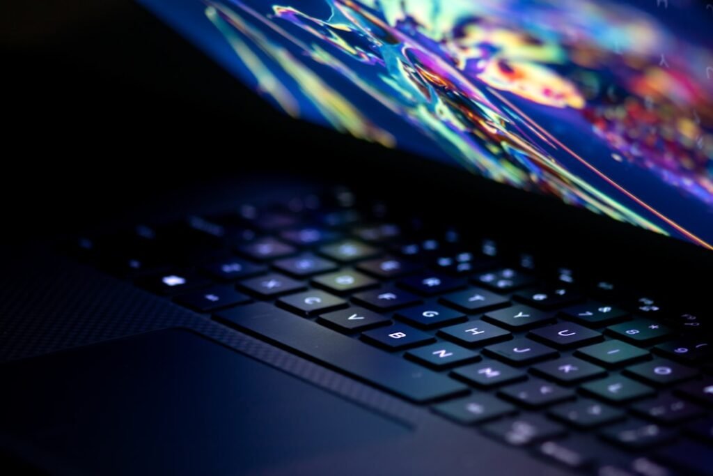 Close-up of a laptop keyboard with a colorful abstract display on the screen